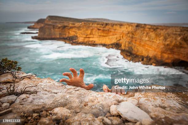 hands holding onto the top of a cliff - cliff stock pictures, royalty-free photos & images