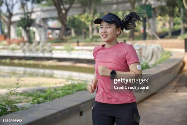 a female with cgm jogging for exercise - blood sugar test stock pictures, royalty-free photos & images