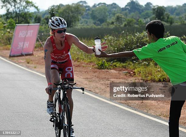 Caroline Steffen of Switzerland takes the drinking bottle during the Meta Man Iron Distance Triathlon on August 31, 2013 in Bintan Island, Indonesia.