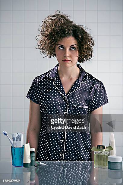 young woman in pajamas in bathroom - messy hair stock-fotos und bilder