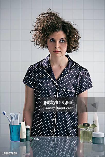 young woman in pajamas in bathroom - cabello desmelenado fotografías e imágenes de stock