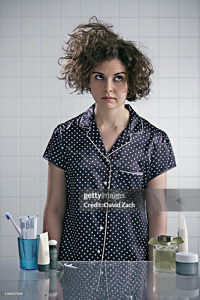 Young woman in pajamas in bathroom