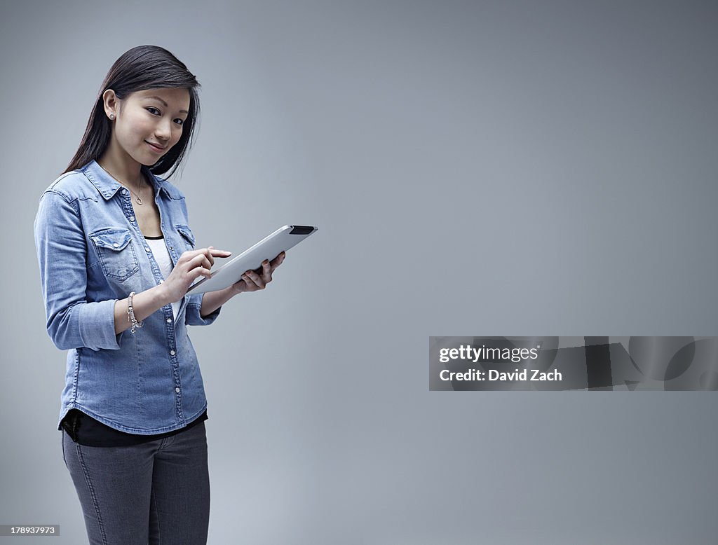 Young Chinese woman using digital tablet