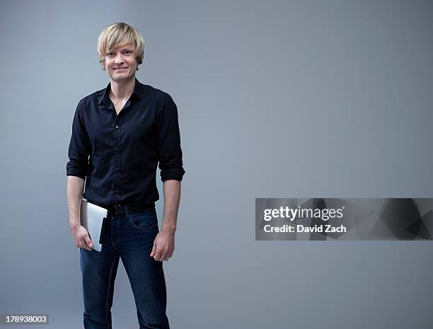 young casual businessman holding digital tablet - man in black shirt stock pictures, royalty-free photos & images