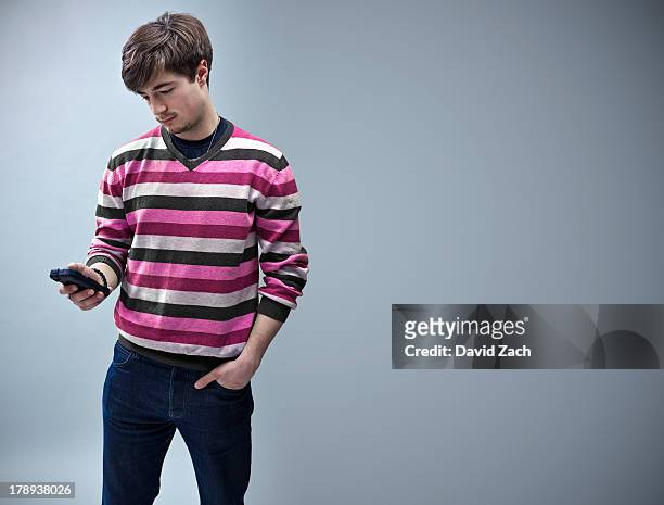 young man looking at mobile phone - 20 24 anni foto e immagini stock