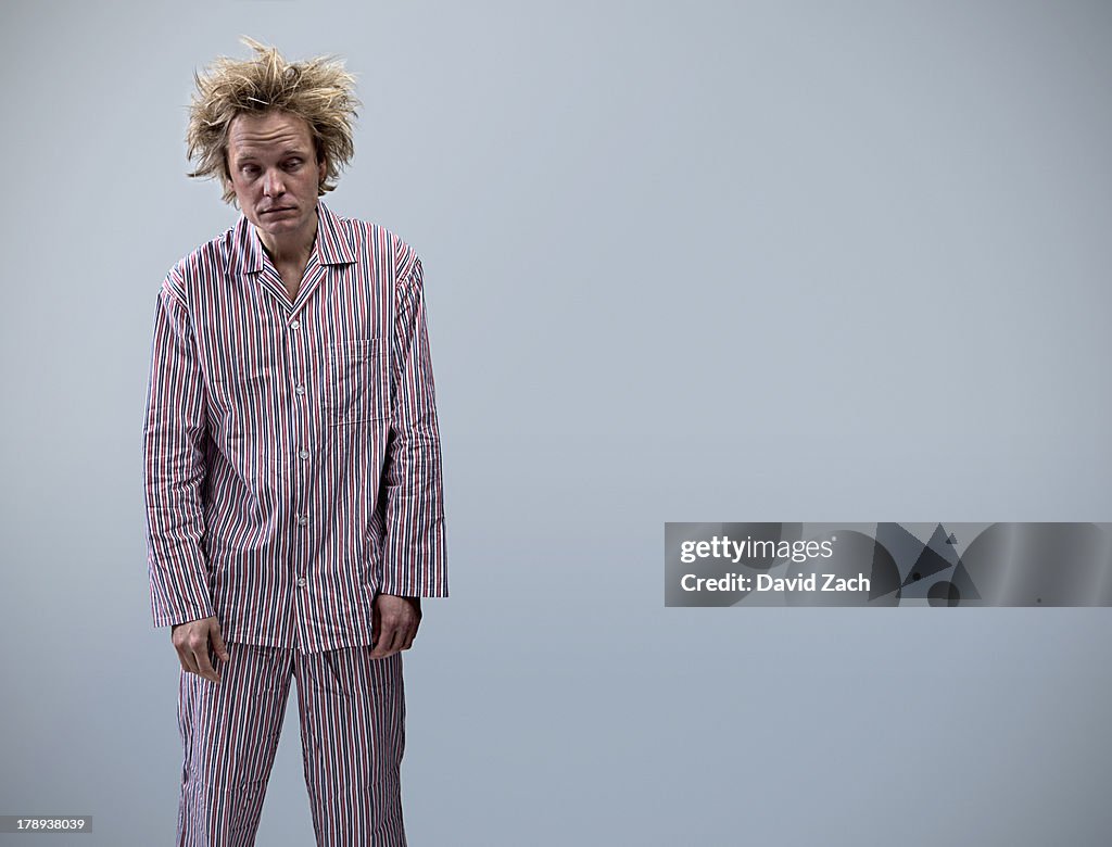Young man in pajamas looking tired, portrait