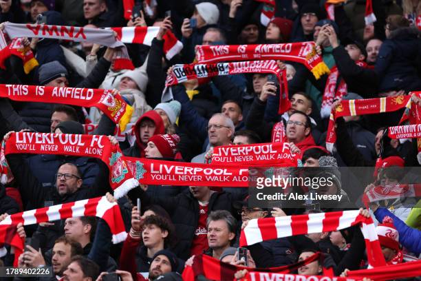 Liverpool fans hold flags aloft in support prior to the Premier League match between Liverpool FC and Brentford FC at Anfield on November 12, 2023 in...