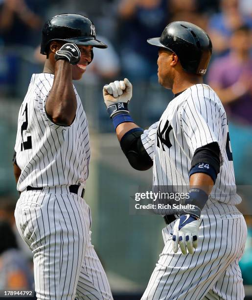 Alfonso Soriano congratulates Robinson Cano of the New York Yankees after Cano's home run in the eighth inning against the Baltimore Orioles in a MLB...