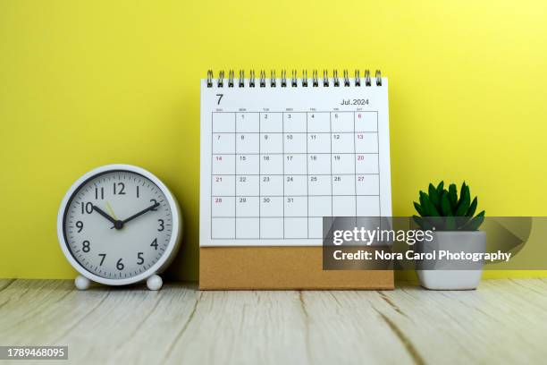 july 2024 desk calendar with alarm clock and potted plant - week seven stock pictures, royalty-free photos & images