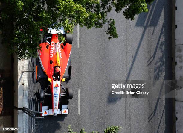 Viso, of Venezuela, driver of the Team Venezuala/Andretti Autosport/HVM Chevrolet Dallara races under some trees during for practice for the Grand...