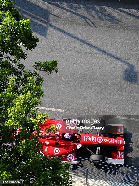 Scott Dixon, of New Zealand, driver of the Target Chip Ganassi Racing Chevrolet Dallara races under some trees during for practice for the Grand Prix...