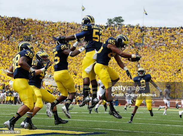 Joe Reynolds of the Michigan Wolverines celebrates with Dymonte Thomas after returning a first quarter blocked punt for a touchdown while playing the...