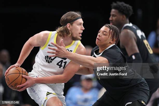 Kelly Olynyk of the Utah Jazz handles the ball against Kenneth Lofton Jr. #6 of the Memphis Grizzlies during the game at FedExForum on November 10,...