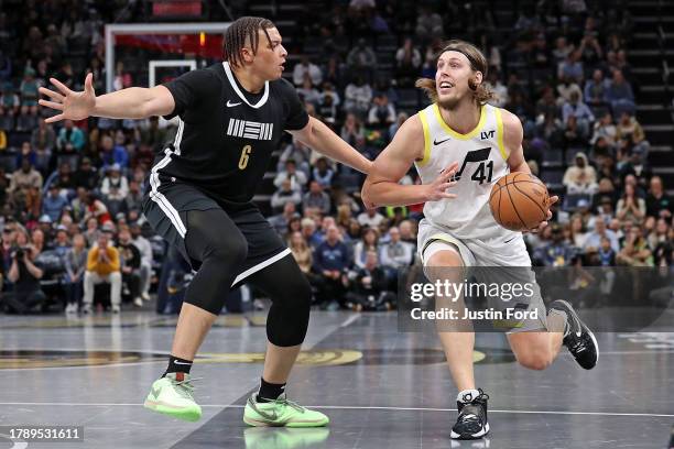 Kelly Olynyk of the Utah Jazz handles the ball against Kenneth Lofton Jr. #6 of the Memphis Grizzlies during the game at FedExForum on November 10,...