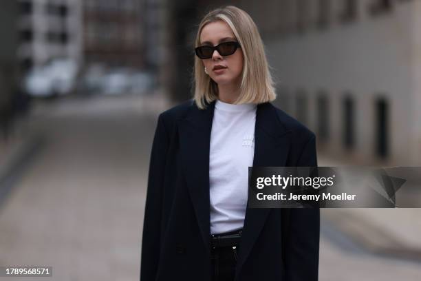 Isabelle Hartmann seen wearing Vehla Eyewear black sunglasses, COS silver earrings, Miu Miu white turtleneck shirt, Zara men dark blue wool long...