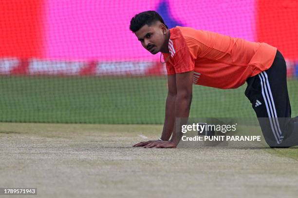 India's Shreyas Iyer inspects the pitch while he attends a practice session at the Narendra Modi Stadium in Ahmedabad on November 18 on the eve of...