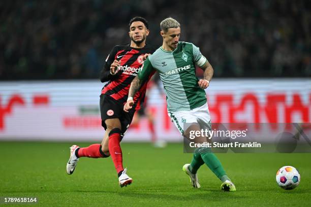 Marco Friedl of Werder Bremen passes the ball whilst under pressure from Omar Marmoush of Eintracht Frankfurt during the Bundesliga match between SV...