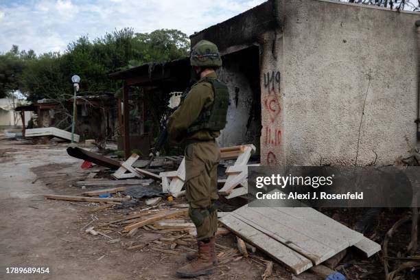 Soldiers walk past houses that were destroyed on Oct 7 when Hamas attacked this kibbutz near the gaza border on November 12, 2023 in Kfar Aza,...