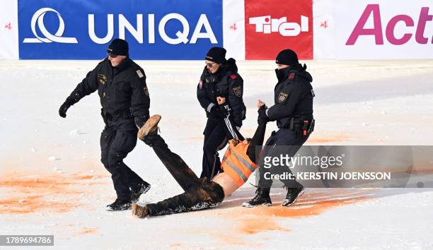 Policeman remove a climate activist of the Last Generation movement from the finish area of the men's Alpine World Cup slalom race in Hochgurgl,...