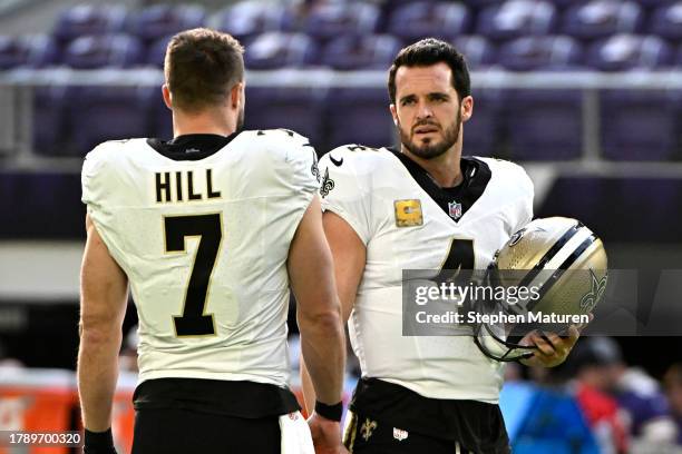 Derek Carr of the New Orleans Saints on the field with teammate Taysom Hill before the game against the Minnesota Vikings at U.S. Bank Stadium on...