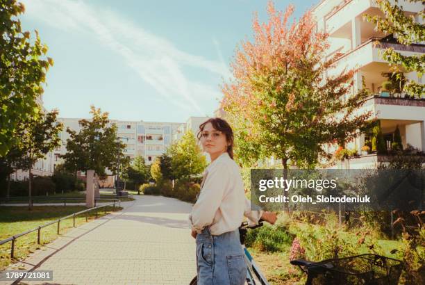 woman with bicycle on bicycle lane in the city - slow living stock pictures, royalty-free photos & images