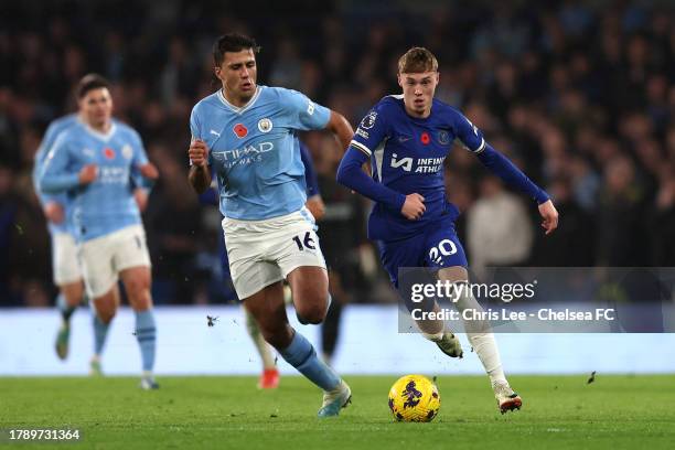 Cole Palmer of Chelsea runs with the ball whilst under pressure from Rodri of Manchester City during the Premier League match between Chelsea FC and...