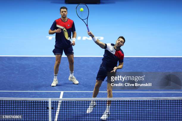 Marcel Granollers of Spain plays a smash shot as partner Horacio Zeballos of Argentina looks on during their Men's Doubles Nitto ATP Finals match...