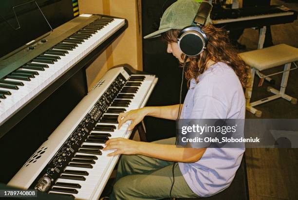 woman playing synth  in headphones in music store - synthesizer stock pictures, royalty-free photos & images