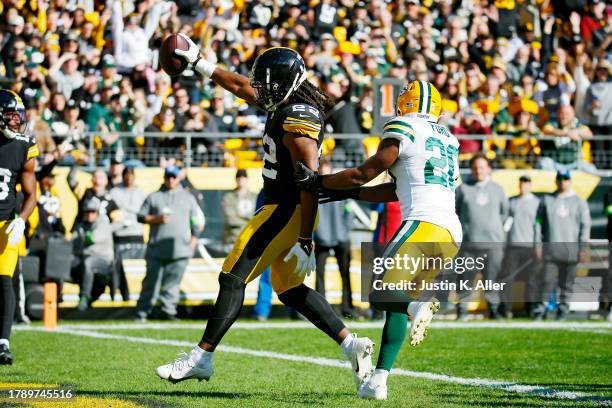 Najee Harris of the Pittsburgh Steelers runs past Rudy Ford of the Green Bay Packers while scoring a rushing touchdown during the first quarter at...