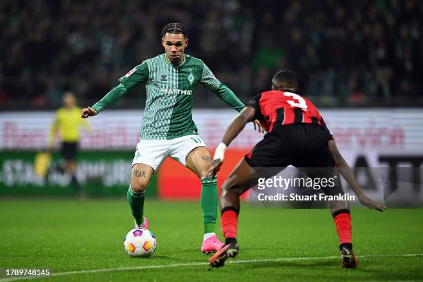 Anthony Jung of Werder Bremen runs with the ball under pressure from Kenneth Schmidt of Sport-Club Freiburg during the Bundesliga match between SV...