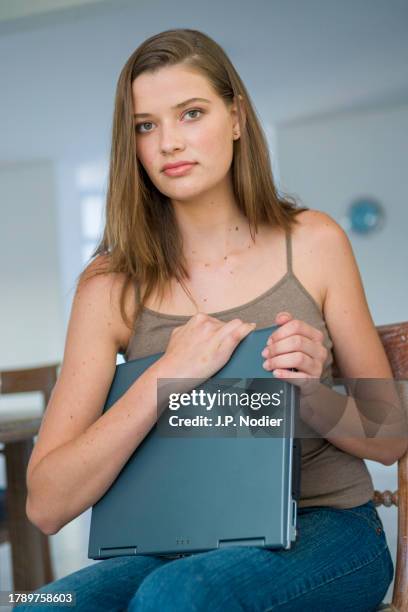 young woman holding a laptop - spaghettiträger stock-fotos und bilder
