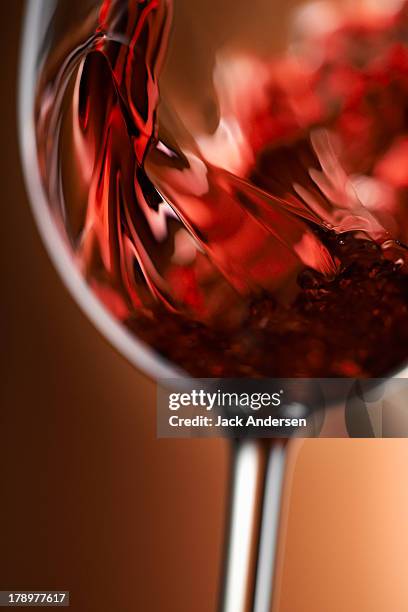 red wine pouring in glass - red wine stockfoto's en -beelden