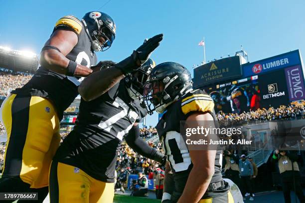 Darnell Washington of the Pittsburgh Steelers and Broderick Jones of the Pittsburgh Steelers celebrate with Jaylen Warren of the Pittsburgh Steelers...