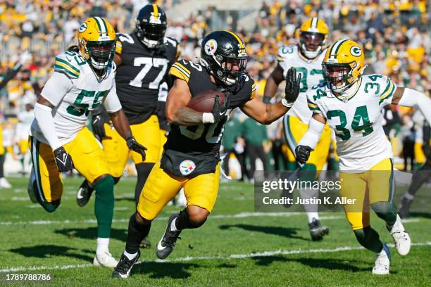 Jaylen Warren of the Pittsburgh Steelers runs past De'Vondre Campbell of the Green Bay Packers and Jonathan Owens of the Green Bay Packers while...