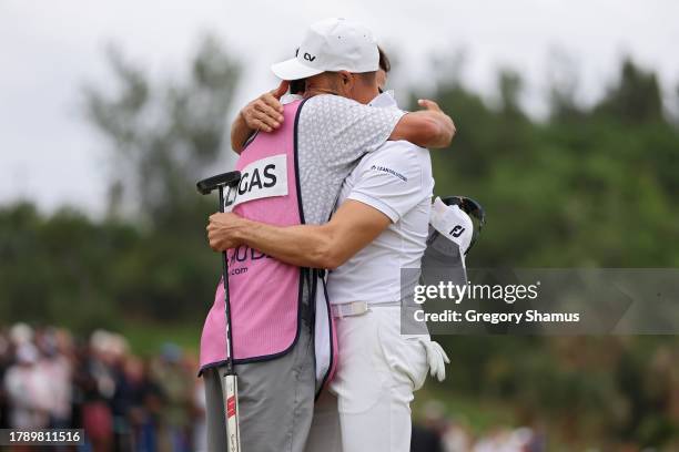 Camilo Villegas of Colombia celebrates with his caddie on the 18th green during the final round after winning the Butterfield Bermuda Championship at...