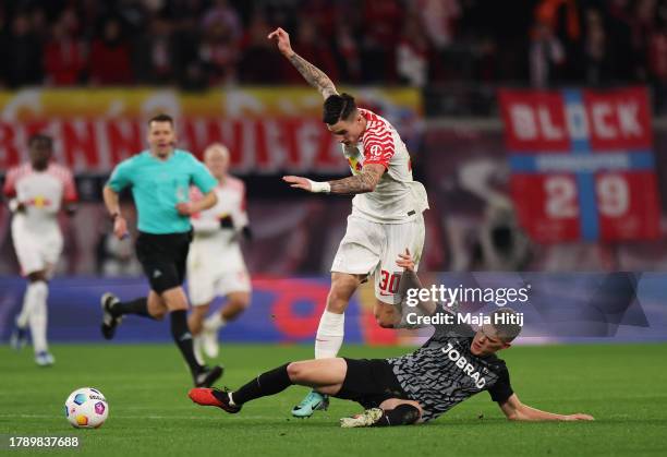 Benjamin Sesko of RB Leipzig clashes with Matthias Ginter of Sport-Club Freiburg during the Bundesliga match between RB Leipzig and Sport-Club...