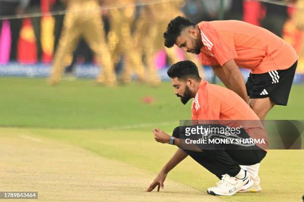 India's Mohammed Siraj and Shardul Thakur inspect the pitch while they attend a practice session at the Narendra Modi Stadium in Ahmedabad on...