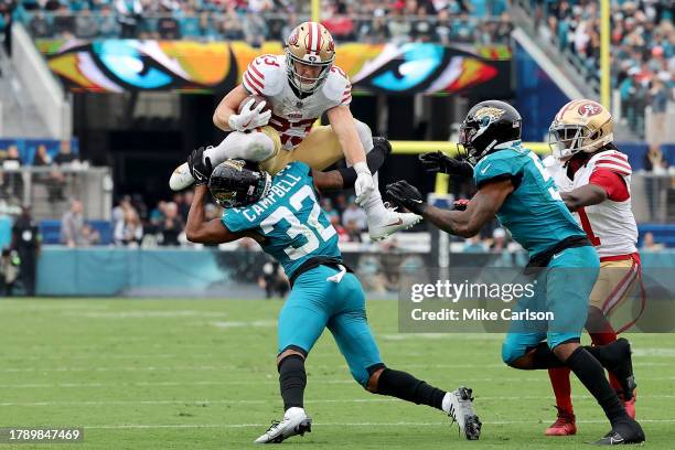 Christian McCaffrey of the San Francisco 49ers hurdles Tyson Campbell of the Jacksonville Jaguars during the second quarter at EverBank Stadium on...