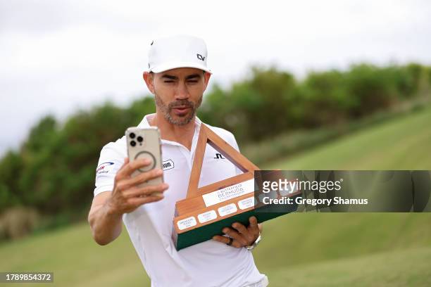 Camilo Villegas of Colombia celebrates take a selfie with the trophy after winning the Butterfield Bermuda Championship at Port Royal Golf Course on...