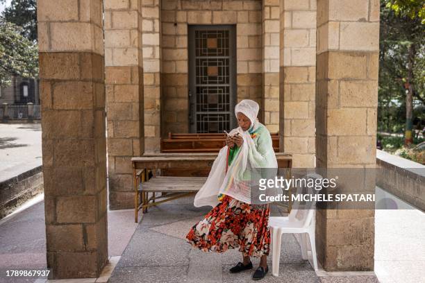 Worshipper of the Ethiopian Orthodox Tewahedo Church prays reading from a Bible at the entrance of the St. Stephen's Church in Addis Ababa on...