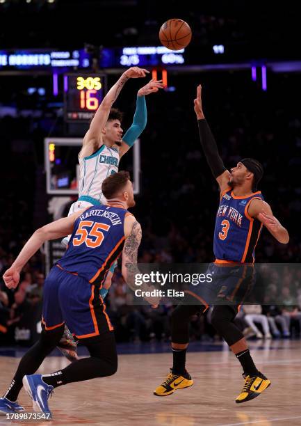 LaMelo Ball of the Charlotte Hornets passes the ball as Isaiah Hartenstein and Josh Hart of the New York Knicks defend during the second half at...