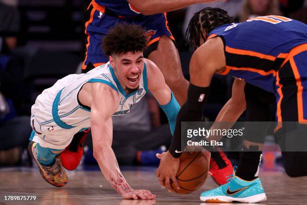 LaMelo Ball of the Charlotte Hornets reaches for the loose ball as Jalen Brunson of the New York Knicks makes the save during the second half at...