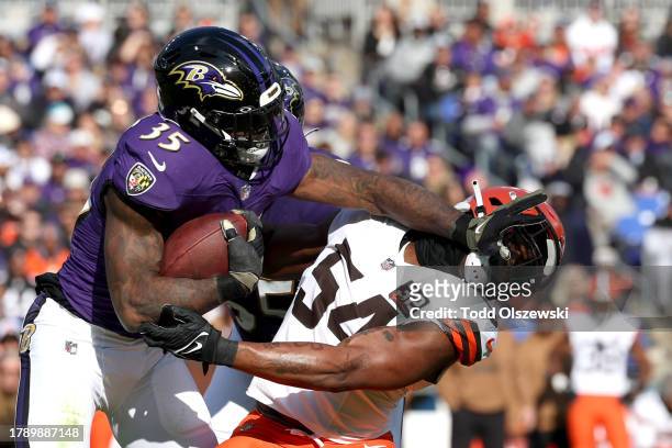 Gus Edwards of the Baltimore Ravens is tackled by Ogbo Okoronkwo of the Cleveland Browns during the first quarter at M&T Bank Stadium on November 12,...