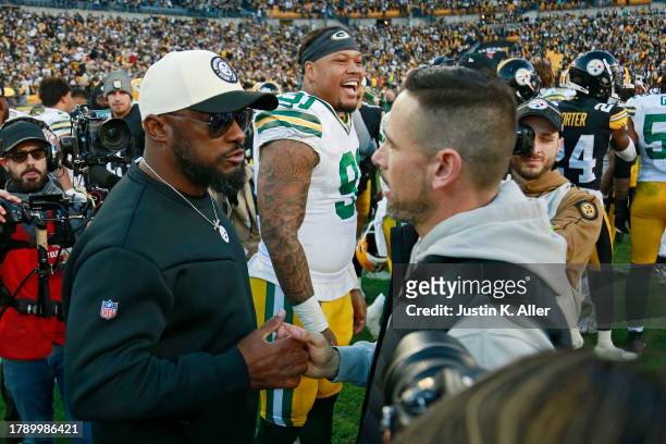 Head coach Mike Tomlin of the Pittsburgh Steelers and head coach Matt LaFleur of the Green Bay Packers shake hands while Preston Smith of the Green...