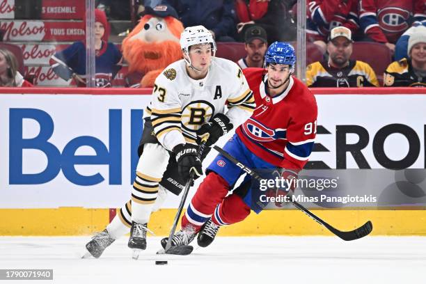 Charlie McAvoy of the Boston Bruins skates the puck against Sean Monahan of the Montreal Canadiens during overtime at the Bell Centre on November 11,...