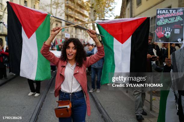 Woman holds a Palestinian flag as she takes part in a demonstration to demand a "stop to the bombings in Gaza" in Montpellier, southern France on...