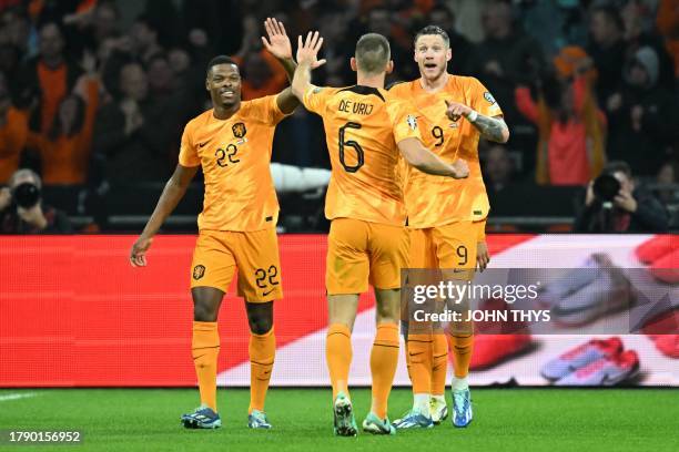 Netherlands' forward Wout Weghorst celebrates with Netherlands' defender Denzel Dumfries after scoring his team's first goal during the UEFA EURO...