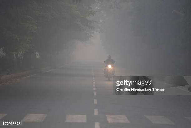 Commuter are seen at sector-29 road amid morning hazy weather conditions near Leisure valley Park, on November 18, 2023 in Gurugram, India.