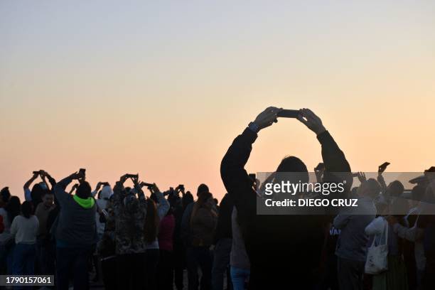 People in Boca Del Río de la Playa Bagdad, in Matamoros, Tamaulipas State, Mexico, take snapshots during the launch of SpaceX's Starship rocket -from...