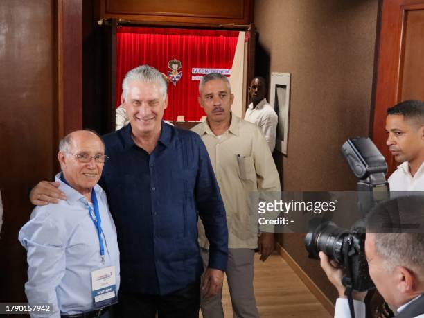 This frame grab from AFPTV video footage shows Cuban President Miguel Díaz Canel posing for a picture with a participant of the IV Nation and...